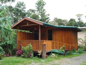 una pequeña casa de madera con porche en Casitas del Bosque Monteverde., en Monteverde