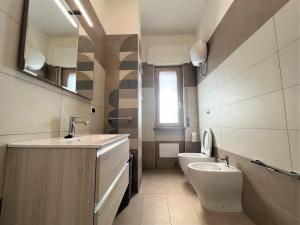 uma casa de banho com um lavatório, um WC e um espelho. em Pompei Next em Scafati