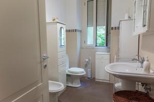 een witte badkamer met een toilet en een wastafel bij LN ETNA HOUSE-villa ad uso esclusivo in Pedara