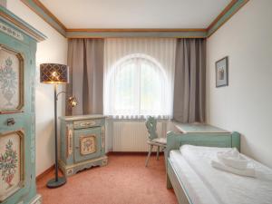 a bedroom with a bed and a desk and a window at Center Rooms & Apartments in Mayrhofen