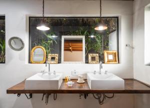 2 lavabos en un baño con 2 espejos en WE Hotel, en Campos do Jordão