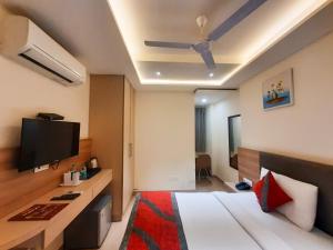 新德里的住宿－Hotel Tripple Tree - Karol Bagh，配有一张床和一台平面电视的酒店客房