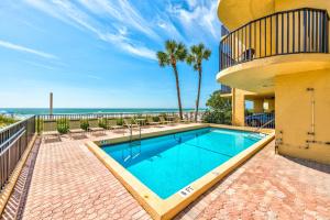 a swimming pool with a view of the ocean at Trillium 2A - Premier in St Pete Beach