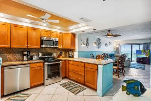 Una cocina con gabinetes de madera y un comedor. en Villa Madeira 504 - Premier, en St Pete Beach