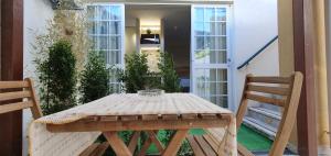 a wooden table and chairs on a patio with a door at Isabel Guest House in Almada