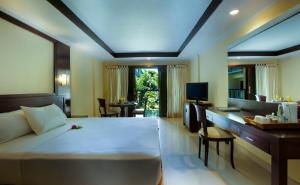 een hotelkamer met een groot bed en een bureau bij Champlung Mas Hotel Legian, Kuta in Legian