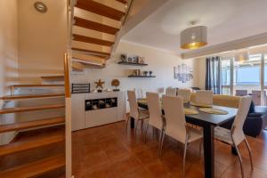 a dining room and living room with a table and chairs at Vista Mar in Porto Santo +56 photos