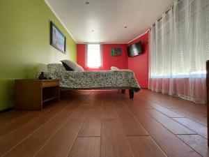 sala de estar con sofá y paredes rojas en Hostal Recuerdos de Familia, en Valparaíso
