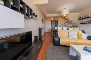 a living room with a couch and a tv at Vista Mar in Porto Santo