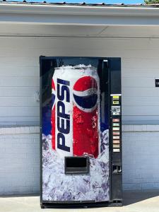 una macchina da coca gigante in un edificio con la neve sopra. di Budget Inn Madill a Madill