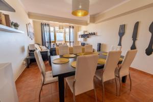 a dining room with a black table and chairs at Vista Mar in Porto Santo
