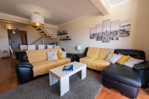 a living room with two couches and a table at Vista Mar in Porto Santo
