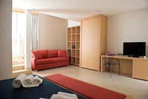 a living room with a red couch and a television at Mon Rêve Resort in Taranto