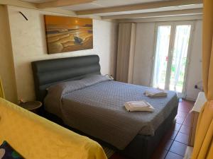 ein Schlafzimmer mit einem Bett mit zwei Handtüchern darauf in der Unterkunft La Dimora di via Manzoni in Catania