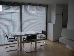 a table and chairs in a room with a large window at Design Apartment Pandreitje Brugge in Bruges