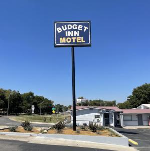 a sign for a motel in a parking lot at Budget Inn Madill in Madill