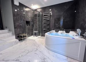 a white bathroom with a tub and a shower at Le Porte luxury apartment in Aosta