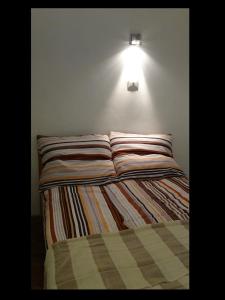 a bed in a room with a light on the wall at Domus Romanus in Ljubljana