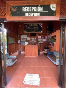 a reception room with benches and a sign for reception at Casa Torre Eco- Lodge in Fortuna