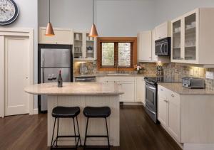 a kitchen with two stools at a kitchen island at Outback Lakeside Vacation Homes in Vernon