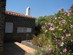 a brick house with pink flowers in front of it at Tranquilos estudios cerca de la playa in Cadaqués