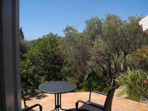 a table and chairs on a patio with trees at Tranquilos estudios cerca de la playa in Cadaqués