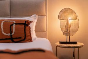 a lamp on a table next to a bed at Palm Beach in Ajaccio