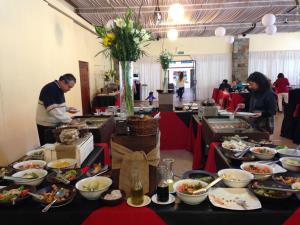 a group of people preparing food in a buffet line at Mantagua Village in Concón