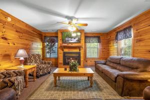 a living room with leather furniture and a fireplace at Poplar Point Condo Unit 12E in Pigeon Forge