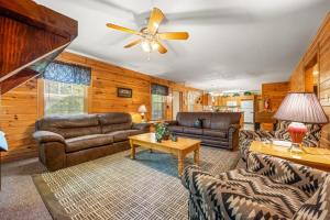 a living room with leather furniture and a ceiling fan at Poplar Point Condo Unit 12E in Pigeon Forge