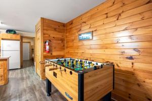 a foosball table in a room with wooden walls at Poplar Point Condo Unit 12E in Pigeon Forge