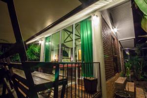 una casa con cortinas verdes en el lateral de ella en Baan B&B Sukhothai en Sukhothai