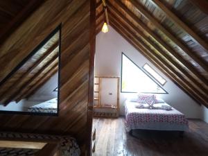 a bedroom in a attic with a bed and a window at Chalet del Pacífico in Jama