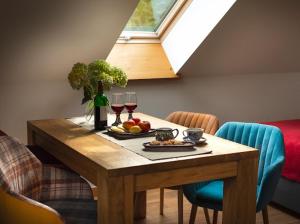 a table with a plate of fruit and wine glasses at Apartamenty U Harrego I Przy Stawie Spa in Kudowa-Zdrój