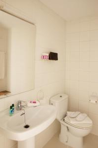 a white bathroom with a toilet and a sink at Apartamentos Golf Mar by La Costa Resort in Pals