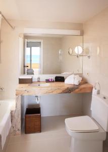 a bathroom with a sink and a toilet and a tub at Apartamentos Golf Mar by La Costa Resort in Pals