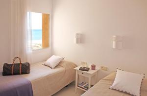 a bedroom with two beds and a window with the beach at Apartamentos Golf Mar I & II by La Costa Resort in Pals