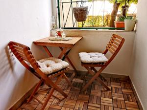 two chairs and a table in a small room with a window at CozyHome The Castle Apartment - Spacious, quiet, high ceiling in Bratislava