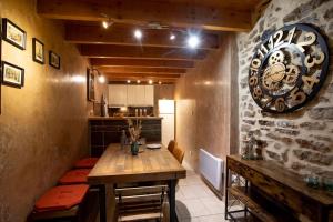 eine Küche mit einem Tisch und einer großen Uhr an der Wand in der Unterkunft L'Hippocampe in Bouzigues