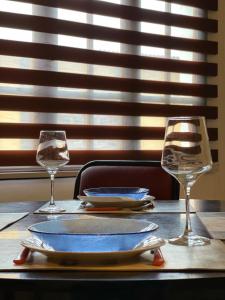 una mesa con un plato y dos vasos. en M&E Dpto Zona Primitiva en Ushuaia