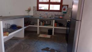 a kitchen with a counter and a refrigerator at Casa Teodoro!!! in Trairi