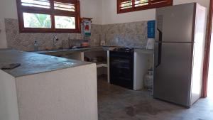a kitchen with a refrigerator and a counter top at Casa Teodoro!!! in Trairi