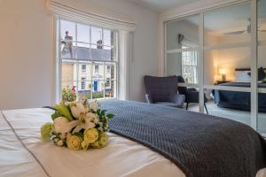 a bedroom with a bed with a bouquet of flowers on it at Crown Street in Bury Saint Edmunds