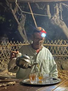 a man sitting at a table with a pot at Le Sommet Naturel in Chefchaouene