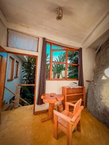 a room with a table and chairs and a window at Lush Atitlán in San Marcos La Laguna