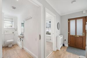 a white bathroom with a toilet and a sink at Estura in Uny Lelant