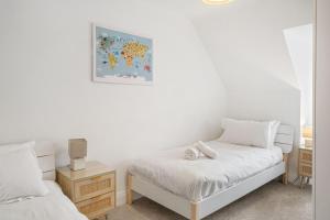 a bedroom with two beds and a painting on the wall at Estura in Uny Lelant