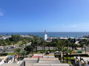 a view of a city with a lighthouse and the ocean at MEERBLICK BEACH-APARTMENT Monte Rojo in San Agustin
