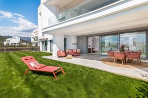 un patio con una silla roja y una mesa en Exclusive New Apartment within Santa Clara and Marbella Golf & Country Club, en Marbella