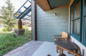 eine Terrasse mit einem Holztisch und einer Bank auf einem Haus in der Unterkunft Zephyr Mountain Lodge Premium-Rated 1102 in Winter Park